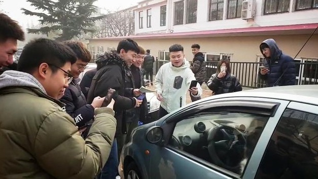 十几个大学生围堵汽车拍照，以为是辆罕见的豪车，其实不然