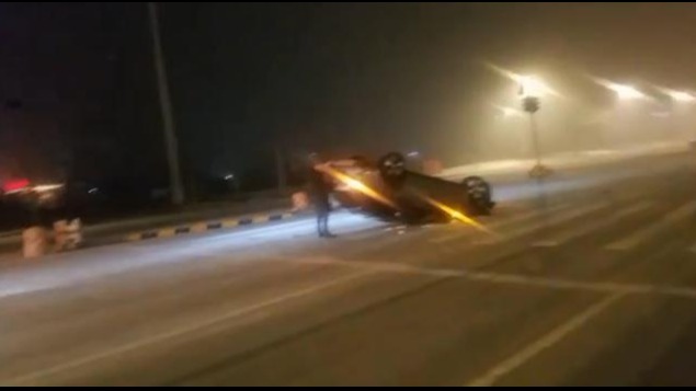 大雪天行车 轿车翻了个“四脚朝天” 路标也被“拦腰折断”